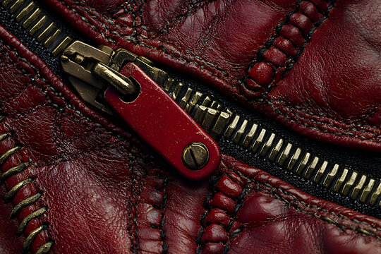 Red leather zipper detail, close-up texture. Fashion design