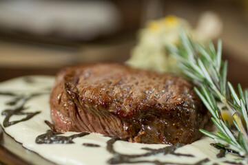Juicy roasted beef steak with rosemary white sauce, a mouthwatering close-up shot.