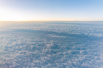 Beautiful orange and pink sunrise over the clouds, view from the plane.