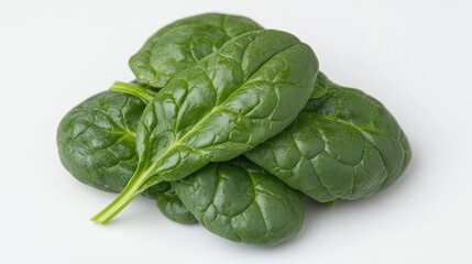 Obraz premium Fresh green baby spinach leaves piled on a clean white background in a brightly lit studio setting.