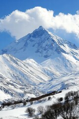 Obraz premium Majestic Snow-Capped Mountain Under Bright Blue Sky and Clouds