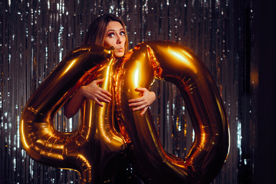 Funny Woman Holding big Balloons Celebrating in her 40s. Surprised lady feeling joyful celebrating her forties 
