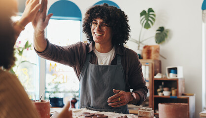 Pottery, happy and man high five in workshop for design, artistic skills and learning in class....