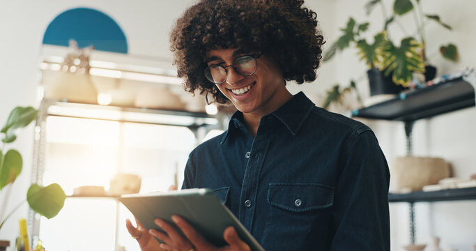 Small business, smile and man with tablet, pottery and happy for positive feedback, online and creative. Browsing, entrepreneur and reading of review for shop, artisan and proud for growth of store