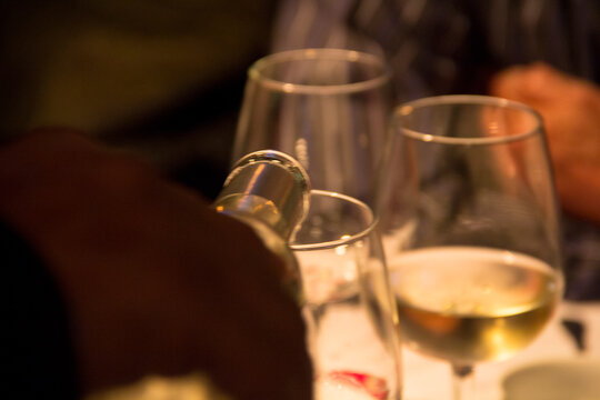 Golden pour of fine Sauternes wine in an intimate fine dining setting.