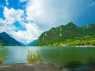 Serene Lake Idro Surrounded by Majestic Mountains and Cloudy sky, Italy, Crone