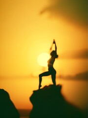 A woman doing yoga on top of a mountain at sunset.