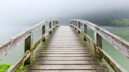 Fototapeta premium Serene Wooden Bridge Over Calm Water Surrounded by Misty Landscape in Tranquil Nature Setting