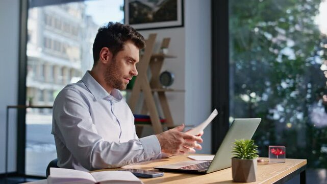 Happy accountant working laptop looking on business documents smiling closeup.