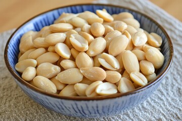 Raw Shelled Peanuts in Blue Bowl on Table with Cloth Background