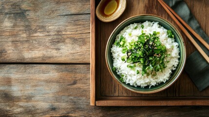 A rustic wooden tray with perfectly cooked Japanese rice served in a ceramic bowl.