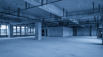 Expansive Empty Industrial Space with Concrete Walls and Natural Light