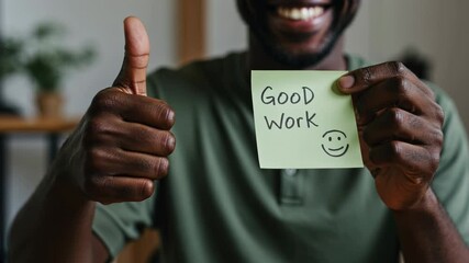 African American professional showing thumbs up and good work note with smile. Positive workplace, office setting. Success, achievement concept, corporate training, motivation. Horizontal video