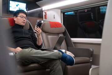 asian man  is using smart phone on a train