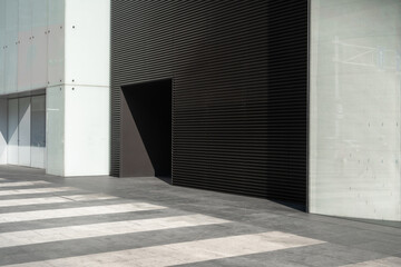 Obraz premium Modern building facade with large door and striped pavemen