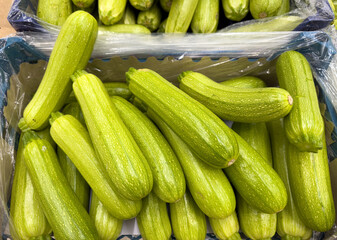 A crate full of green zucchini