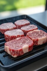 Fototapeta premium Fresh Raw Wagyu Beef Steaks on a Griddle Cooking Surface