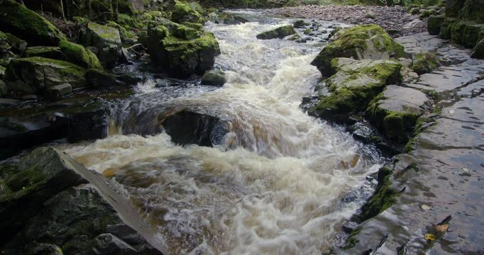 mid shot of the cascading water of the river Mellte entering The Porth yr Ogof Cave