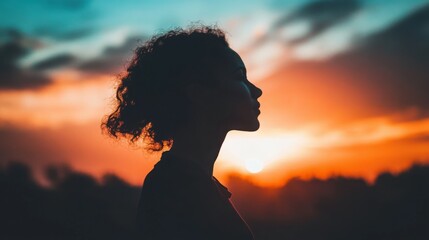Silhouette of a Woman Against Dramatic Sunset Sky with Clouds