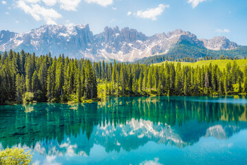Karersee mountain lake in the Dolomites landscape, South Tyrol alps, Italy, also known lake Carezza. Reflection green on lake.