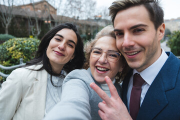Fototapeta premium Happy family taking selfie outdoors making victory sign
