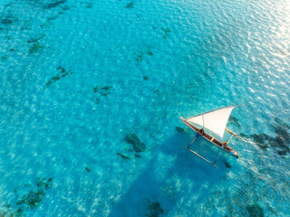 Aerial view of the sailboat on blue sea at sunset in summer