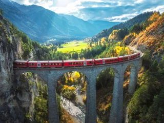 Aerial view of red train on Landwasser viaduct in autumn in Alps