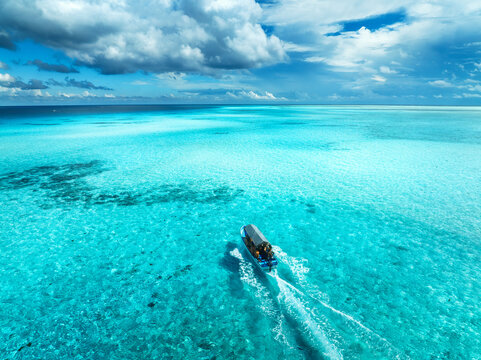 Aerial view of floating boat in turquoise water on sunny day