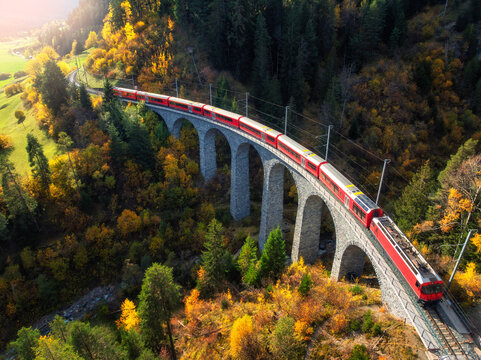 Aerial view of red train on Landwasser viaduct in autumn in Alps