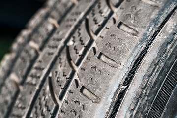Close-up of worn car tire with visible tread damage