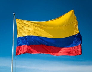 Colombia flag waving in the wind against a blue sky background