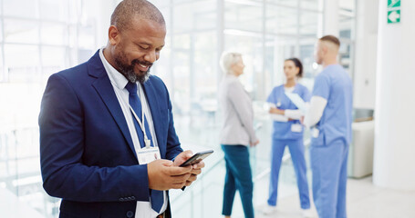 Businessman, investor or medical funding with phone for online investment or healthcare campaign at hospital. Happy man, board director or shareholder with smile on mobile smartphone for health app