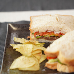Homemade sardine sanwich with potato chips.
