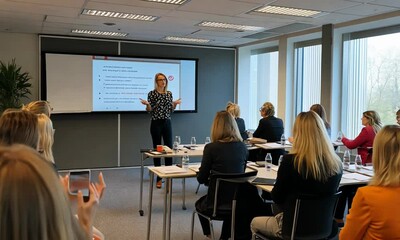 Business presentation in a modern office setting with a speaker engaging an audience of professionals