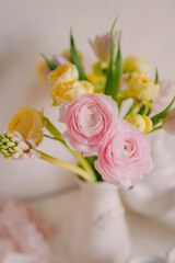 Soft Pastel Ranunculus and Yellow Roses in a Glass Vase