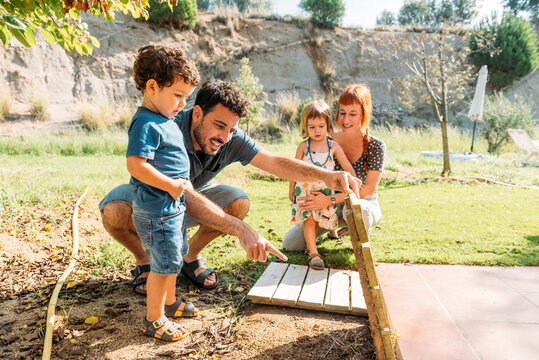 Family Enjoys Time Together in Garden While Searching for a Cricket