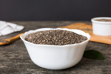 Chia seeds in bowl and spoon on colored background. Healthy Salvia hispanica in small bowl. Healthy superfood