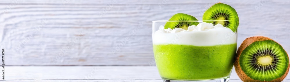 Poster glass filled with kiwi juice placed on a wooden table with fresh kiwis and a blurred background