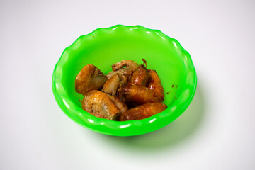 Green plastic bowl containing fried shrimp. The background is white.