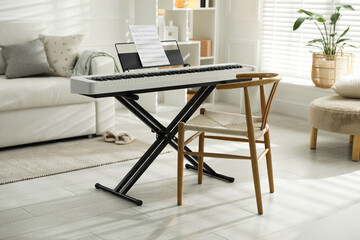 Synthesizer with music sheet and chair at home