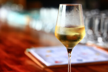 a glass of white wine served in a restaurant, abstract background of a summer restaurant