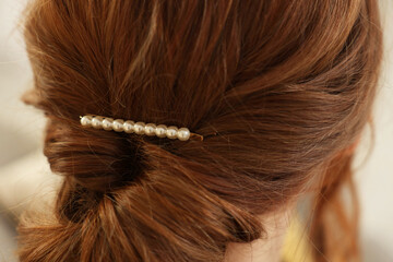 Teenage girl with stylish hair clip indoors, back view