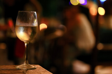 a glass of white wine served in a restaurant, abstract background of a summer restaurant