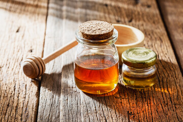 jar of honey dipper on wooden background