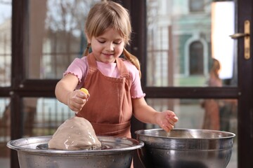 Hobby and craft. Little girl making pottery indoors