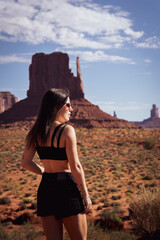 Unrecognizable young woman with her back to the impressive formations of Monument Valley, in the United States.