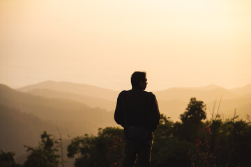 landscape and travel concept with man see sunrise and layer of mountain and mist with forest on...