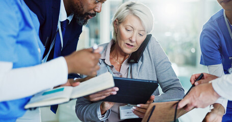 Mature woman, director and multitasking with medical team for overworked pressure or chaos at busy hospital. Female person, healthcare employee or colleagues with tablet, workload or stress at clinic