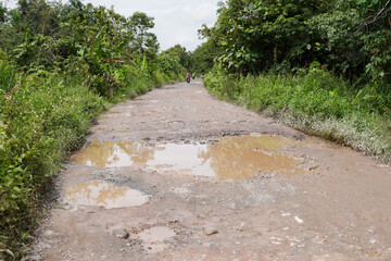 Damaged potholed roads that are flooded after rain. hampering village transportation access to the city. Kubu Raya, West Kalimantan - December 14, 2024