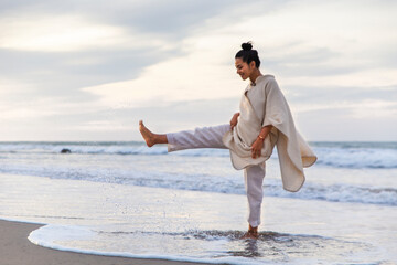 Cheerful woman playing in water at beach